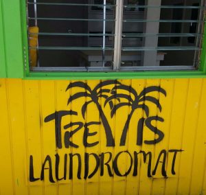 Trellis Laundromat logo spray paint building with windows
