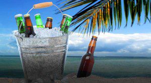 Cold beers chilling on a beach under palm trees.