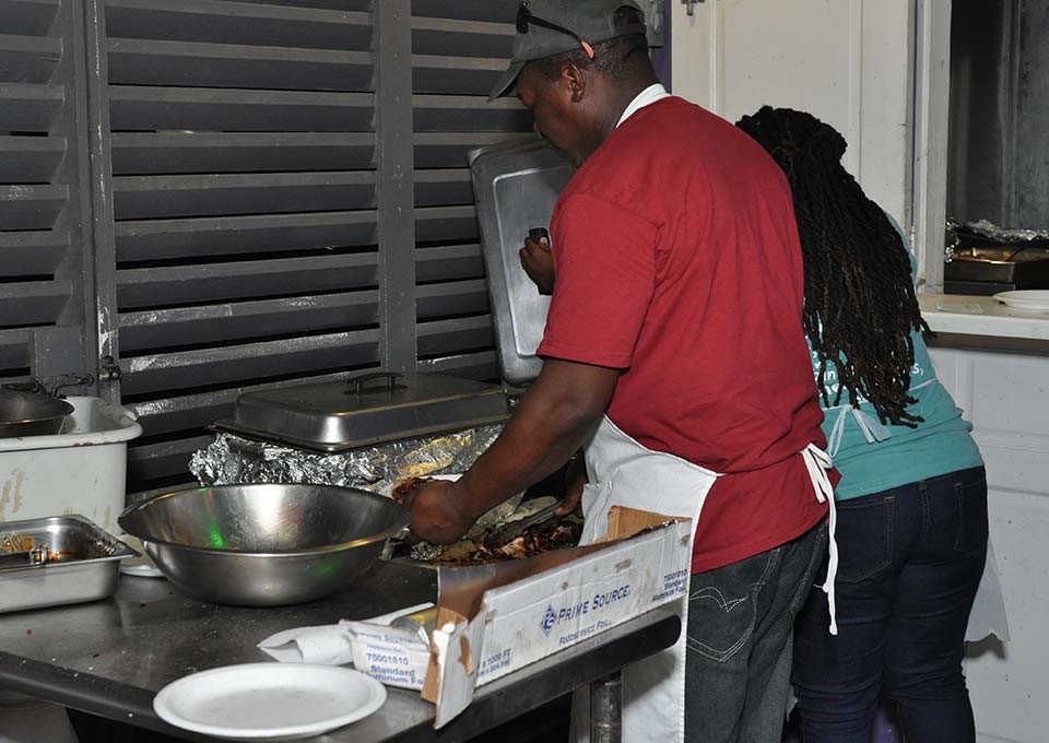 Chefs preparing jerk and BBQ meals
