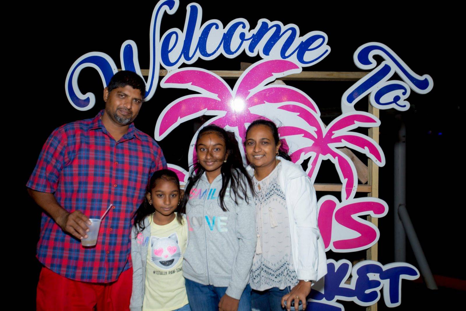 A family standing in front of the welcome sign