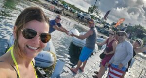 Group of friends enjoying a day by the marina, holding a large fish.