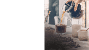 Pouring coffee into a glass mug.