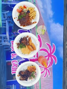 Three plates of food on colorful table.