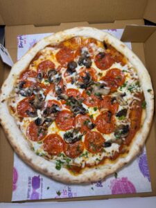 Pepperoni and mushroom pizza in a box.