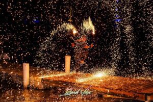 Fire performer surrounded by glowing sparks.