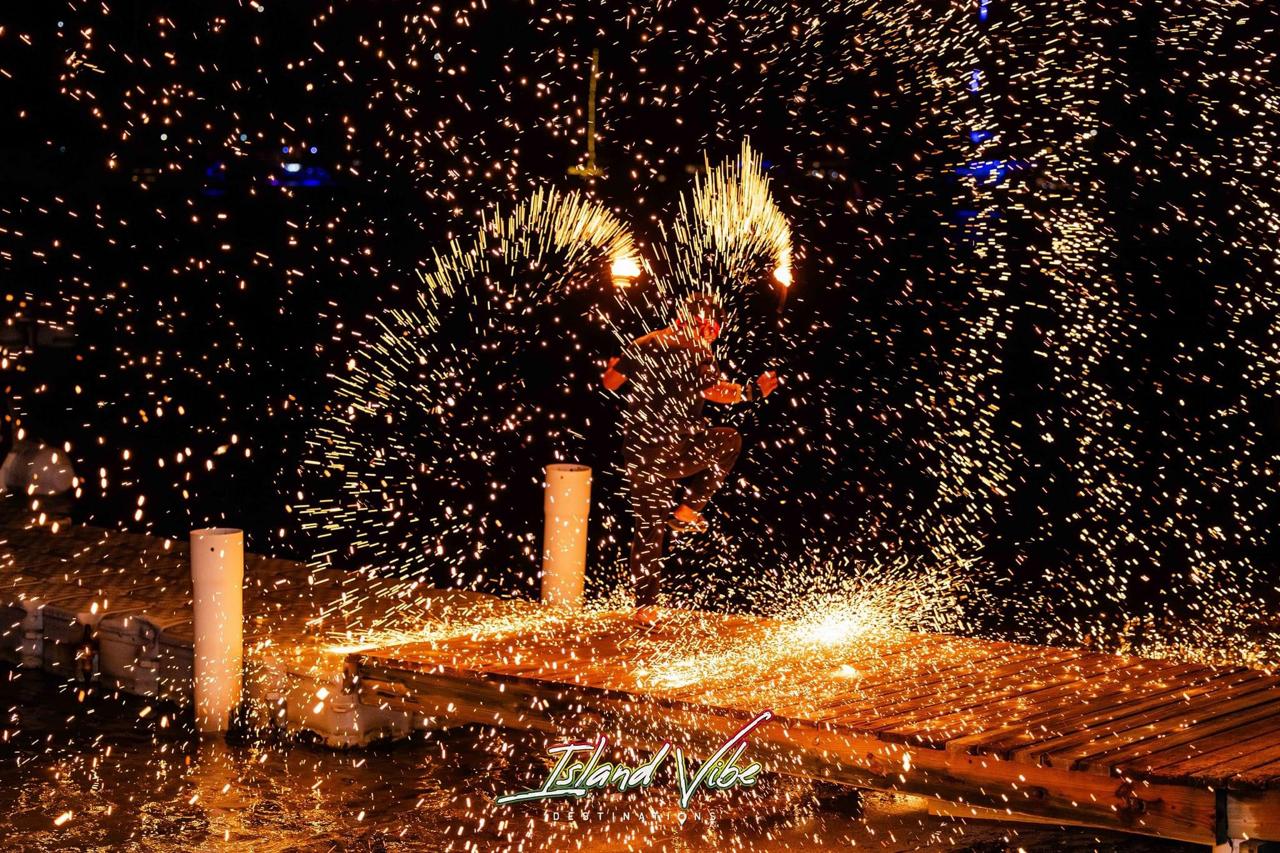 Fire performer creating sparks on wooden dock.