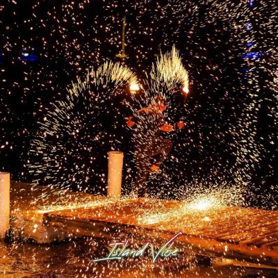 Fire performer surrounded by glowing sparks.